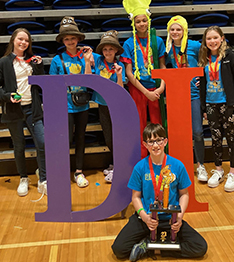 Group of student in blue t-shirts with trophy next to DI letters